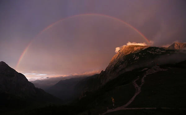 A rainbow spans over the Hohes Goell and Schneibstein mountains near the