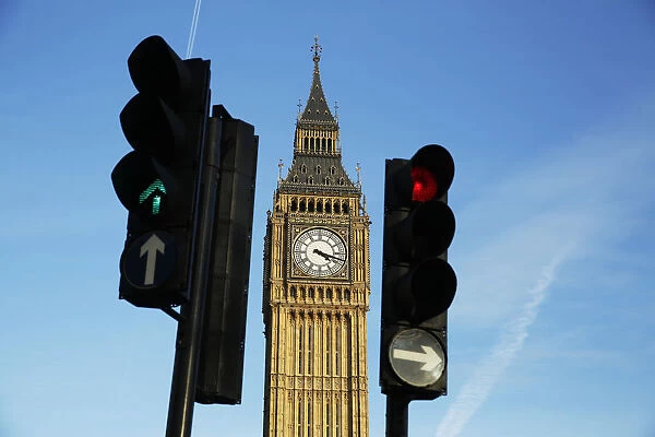 Red and green traffic lights direct traffic in front of the Big Ben bell tower at the