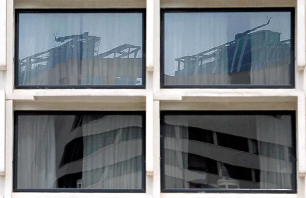 Reflection of construction sites is seen on glass panels of a building in Colombo