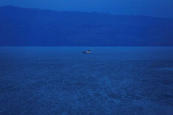 A rescue boat is seen at a location of a ferry that sank earlier this week in Lake Toba