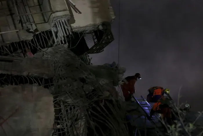 Framed Print : Rescue personnel search the debris of a 17-storey apartment building that collapsed after