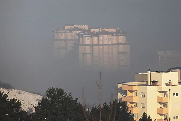 Residential buildings are seen amid morning smog in Pristina