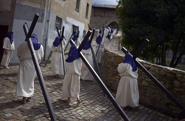 Residents dressed as penitents take part in an Easter Passion Play on Good Friday in the