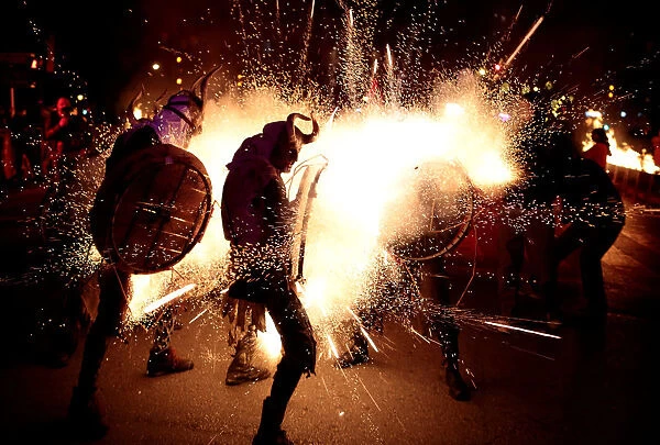 Revellers dressed as devils walk among fireworks during Correfocs in Palma de Mallorca
