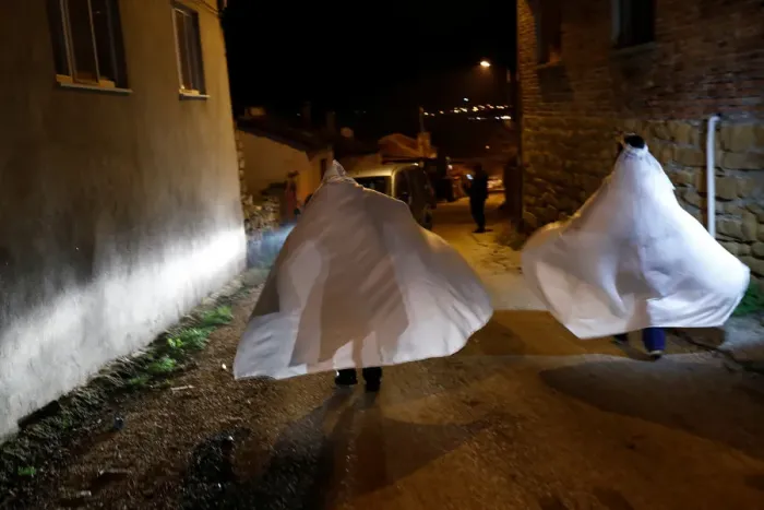 Framed Print : Revellers wrapped in white sheets walk during the aeBocuk nightA Framed Print : Revellers wrapped in white sheets walk during the aeBocuk nightA