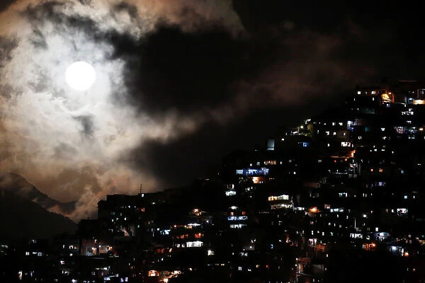 The rising supermoon is seen over the slum of Petare in Caracas