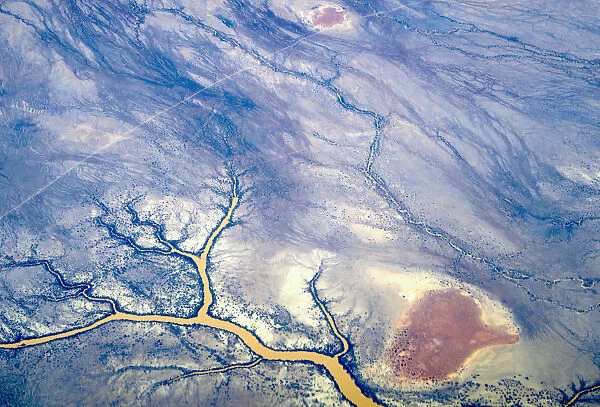 River systems can be seen flowing near sand dunes in outback Queensland