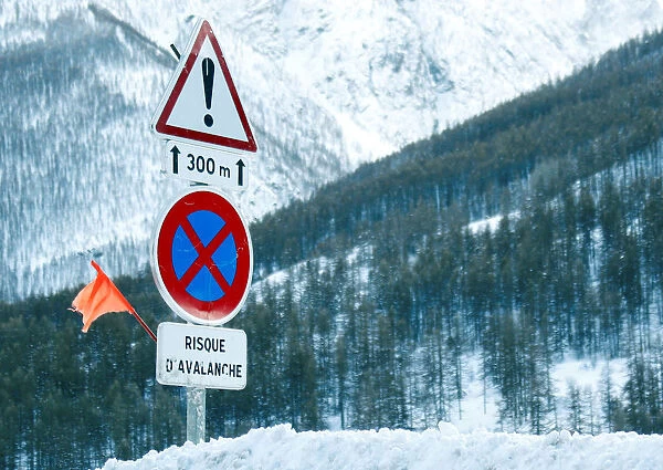 Road signs are pictured on a snow-covered road in Saint-Pancrace as winter weather