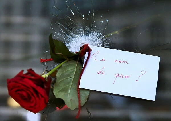 A rose placed in a bullet hole in a restaurant window the day after a series of deadly