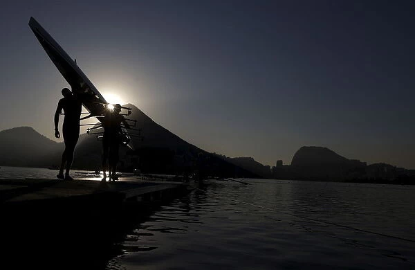 Rowing athletes carry boat ahead of training session at the World Rowing Junior Championships