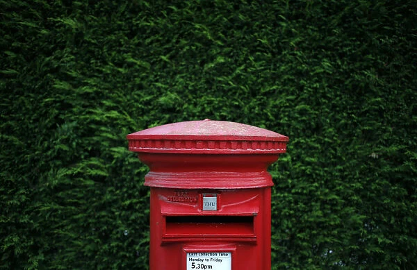 A Royal Mail post box stands on a street corner in Manchester