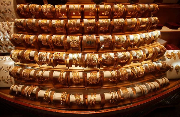 Sets of gold bangles are displayed in a showcase of a showroom selling bridal jewellery