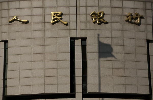 The shadow of a Chinese national flag is casted on the headquarters of the Peoples Bank of China