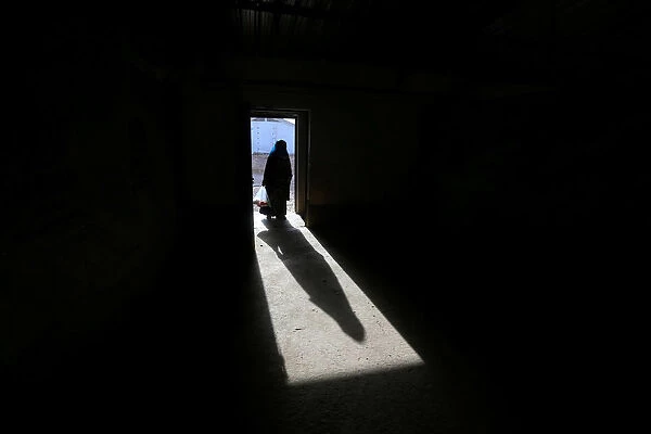 The shadow of a displaced old woman is seen in Hassan Sham camp, east of Mosul