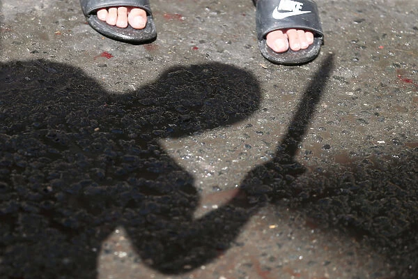 Shadow of a Shi ite Muslim man is seen as he flagellates himself during a religious