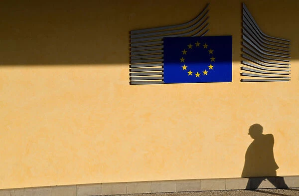The shadow of a worker is seen beside the EU Commission building in Brussels, Belgium