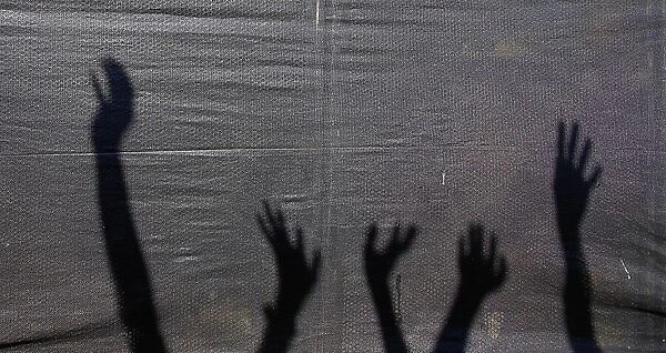 Shadows of the arms of supporters of Indonesian presidential candidate Sukarnoputri