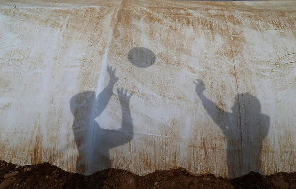 Shadows are cast by displaced Iraqi children, who fled the Islamic State stronghold of Mosul