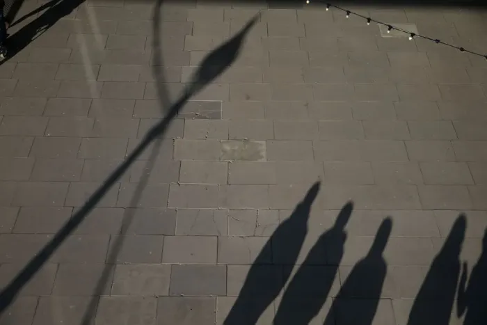 Framed Print : The shadows of pedestrians are cast on the pavement as they walk along the South Bank in Framed Print : The shadows of pedestrians are cast on the pavement as they walk along the South Bank in