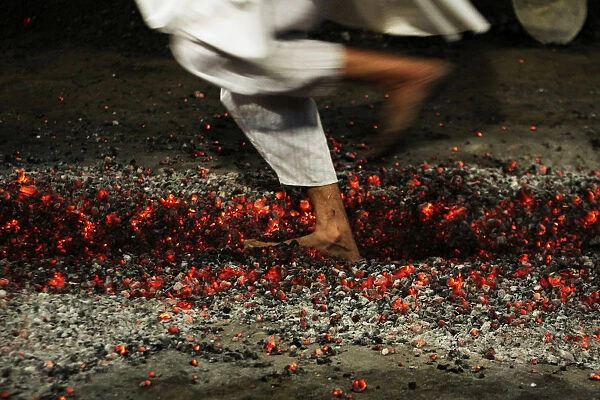 A Shi ite Muslim boy runs on burning charcoals as part of the Ashura religious festival