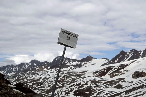 A sign marks the border between Italy and Austria at the alpine pass Hochjoch in the