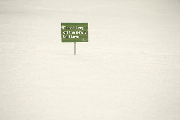 A sign is seen during a snow flurry in Canary Wharf, London