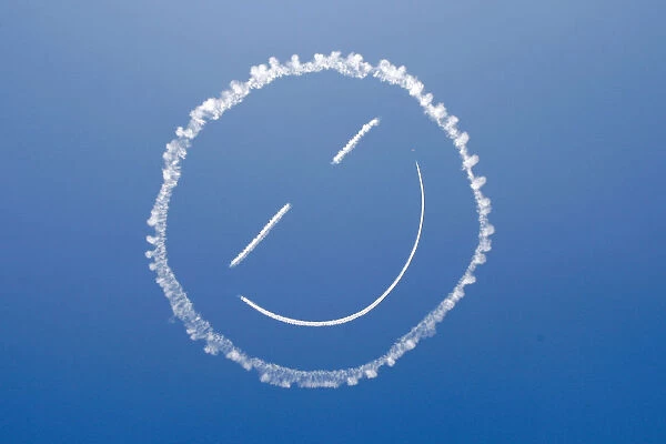 A sky writer draws a smiley face in the sky at start of Los Angeles County Air Show