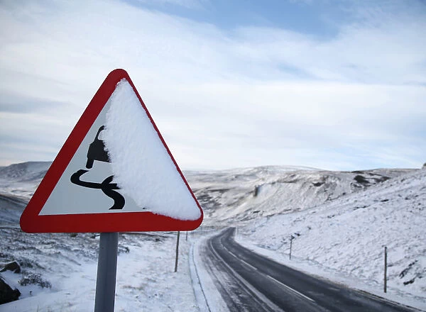A slippery road warning sign is covered in snow on the A93 in Perthshire, Scotland