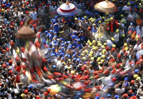 A slow motion picture of devotees carrying chariots as they participate in the Chariot