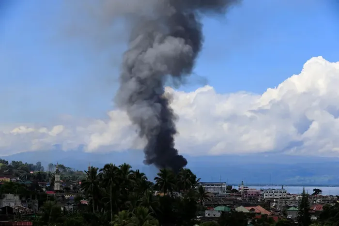 Framed Print : Smoke billows from a burning building in Marinaut village as government troops continue Framed Print : Smoke billows from a burning building in Marinaut village as government troops continue