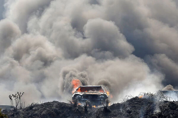 Smoke billows from burning cars during a fire at a plot where police kept seized vehicles