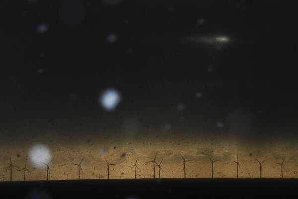 Snow begins to fall in front of wind turbines near the village of Jaywick in Britain