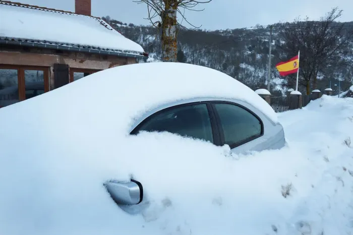 Framed Print : A snow covered car is parked next to a Spanish flag in Entrambasaguas