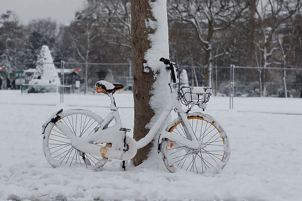 Snow covers a bicycle at the Champ de Mars in Paris
