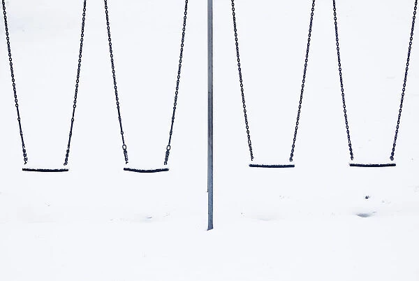 Snow sits on childrens swings at a playground in Lyminge near Folkestone in southern