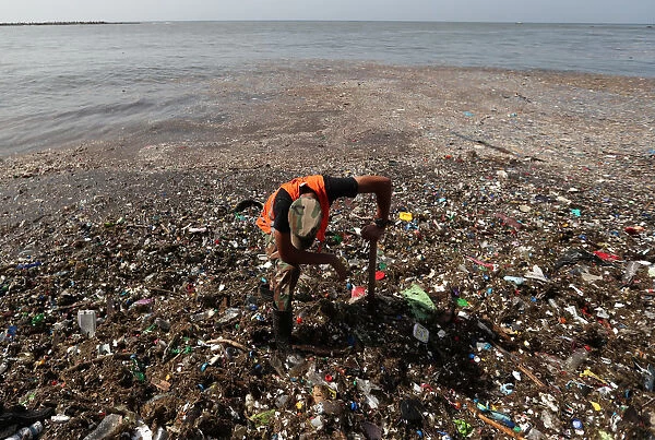 A soldier pauses while cleaning plastic and other debris on the shores of Montesinos