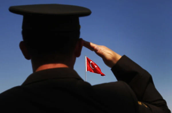 A soldier salutes the Turkish flag during a parade to mark the 88th anniversary of