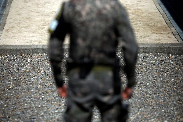 A South Korean soldier stands guard near the concrete borderline at the truce village of