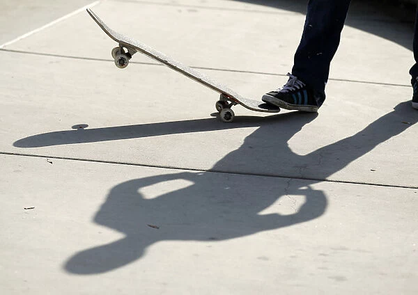 SPORT SKATEBOARDING A skateboarder casts a shadow on the conrete