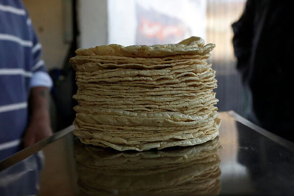 Stack of freshly made corn tortillas is weighted at a tortilla factory in Mexico City