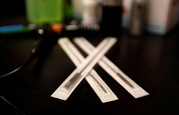 Stainless steel needles lie on a desk in a tattoo studio in Prague