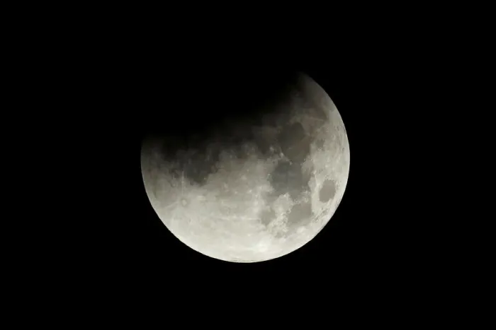 Framed Print : The start of a lunar eclipse is shown over the ocean in Oceanside, California