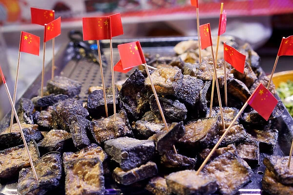 Stinky tofu with cocktail sticks are seen at a street market in the township of Guiyu