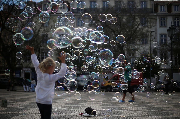 A street artist performs with soap bubbles at Rossio square in downtown Lisbon