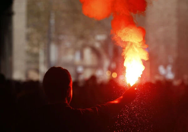 A student holds a lit flare during a demonstration in Rome