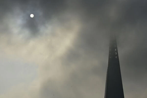 The sun begins to shine through morning fog next to the Shard in central London