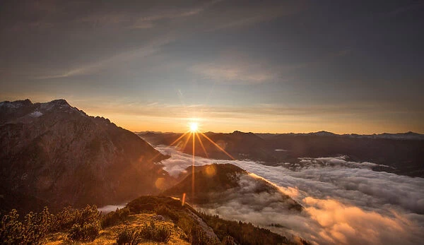 The sun rises over mountain summits in the Austrian village of Absam