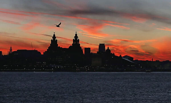 The sun rises across the river Mersey over Liverpool