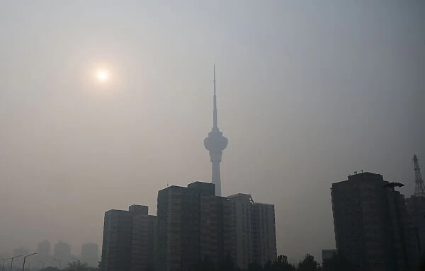 The sun is seen above buildings during a heavily hazy day in Beijing
