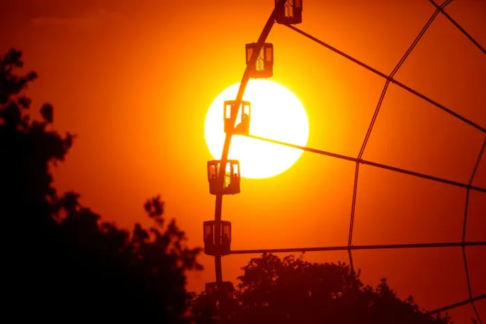 Framed Print : The sun is seen through the giant Ferris wheel at Place de la Concorde at sunset in Paris
